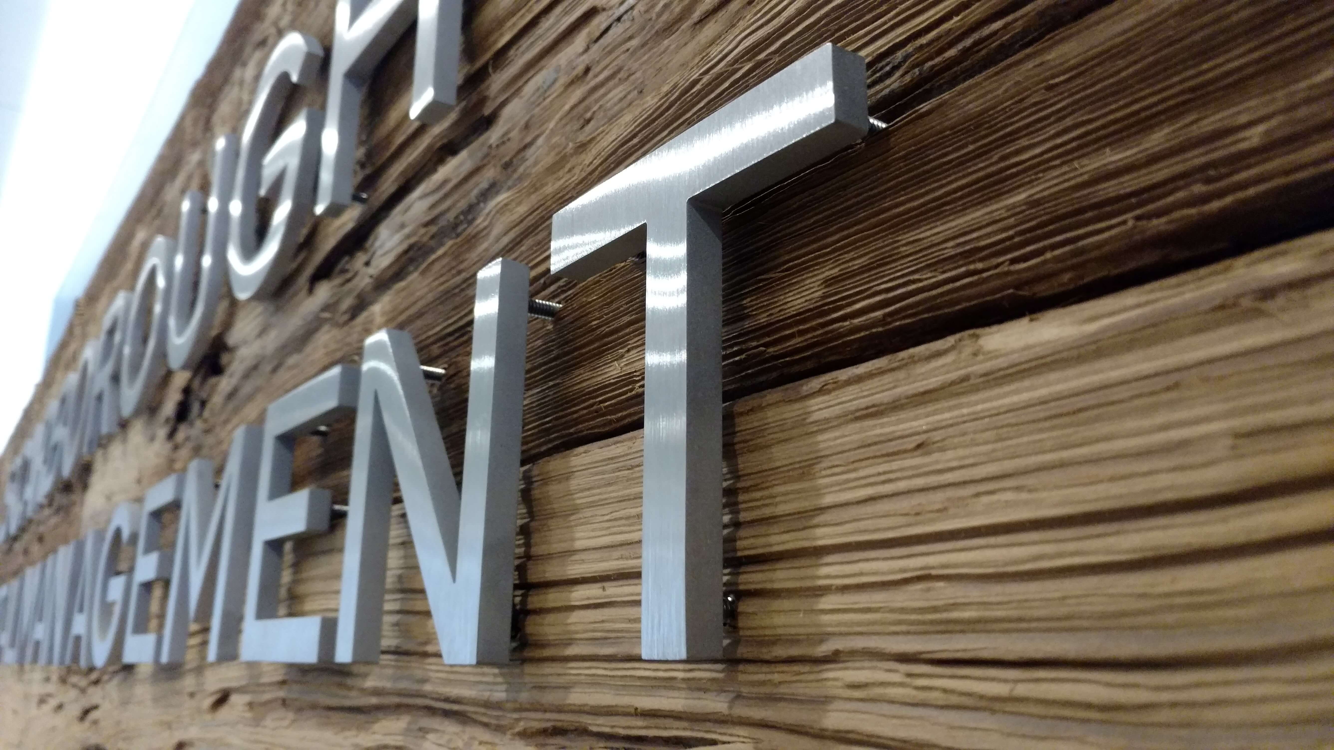 Close-up of dimensional acrylic letters mounted on a reception wall