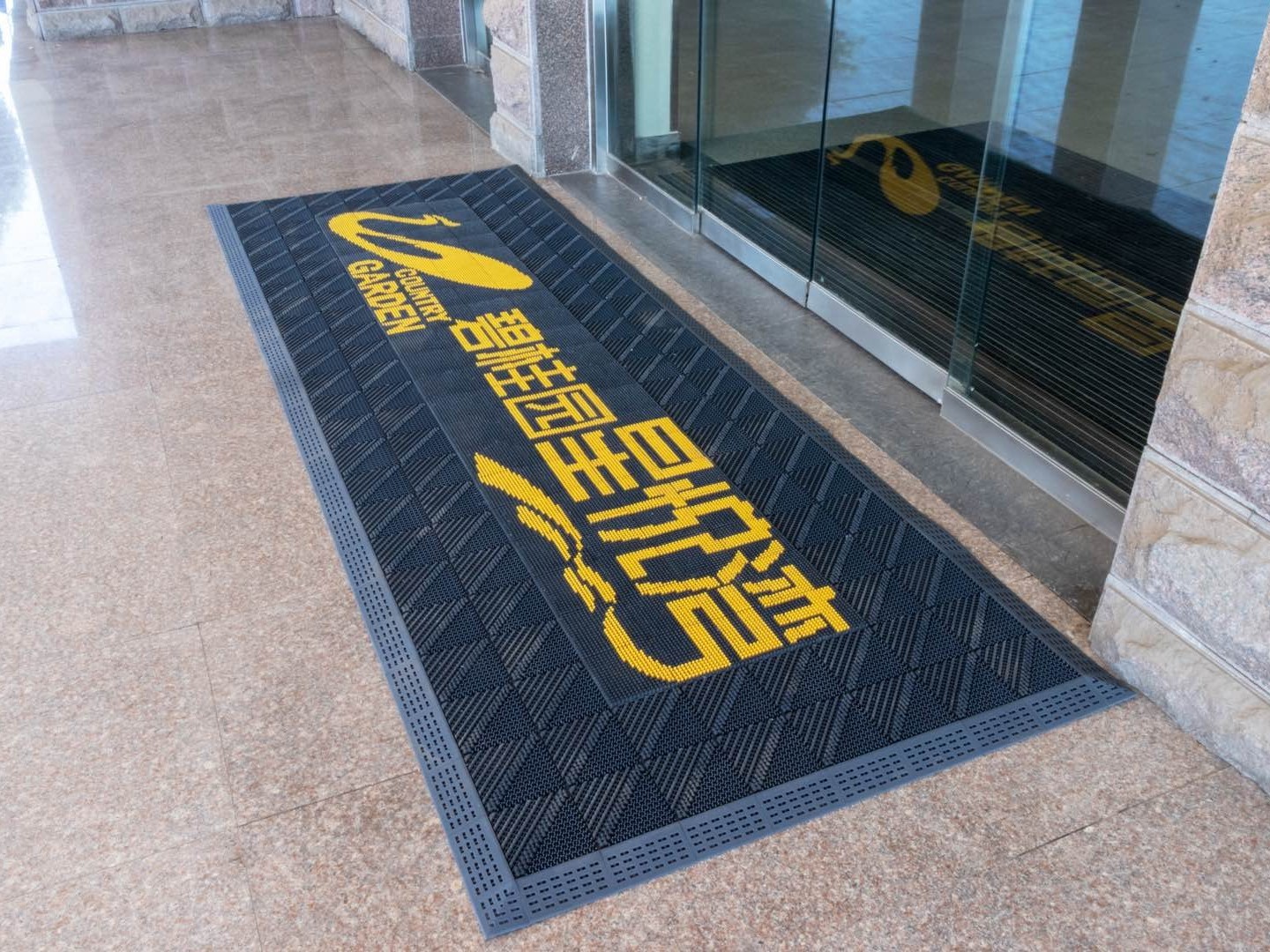 Custom logo mat surface and edge detail at floor level