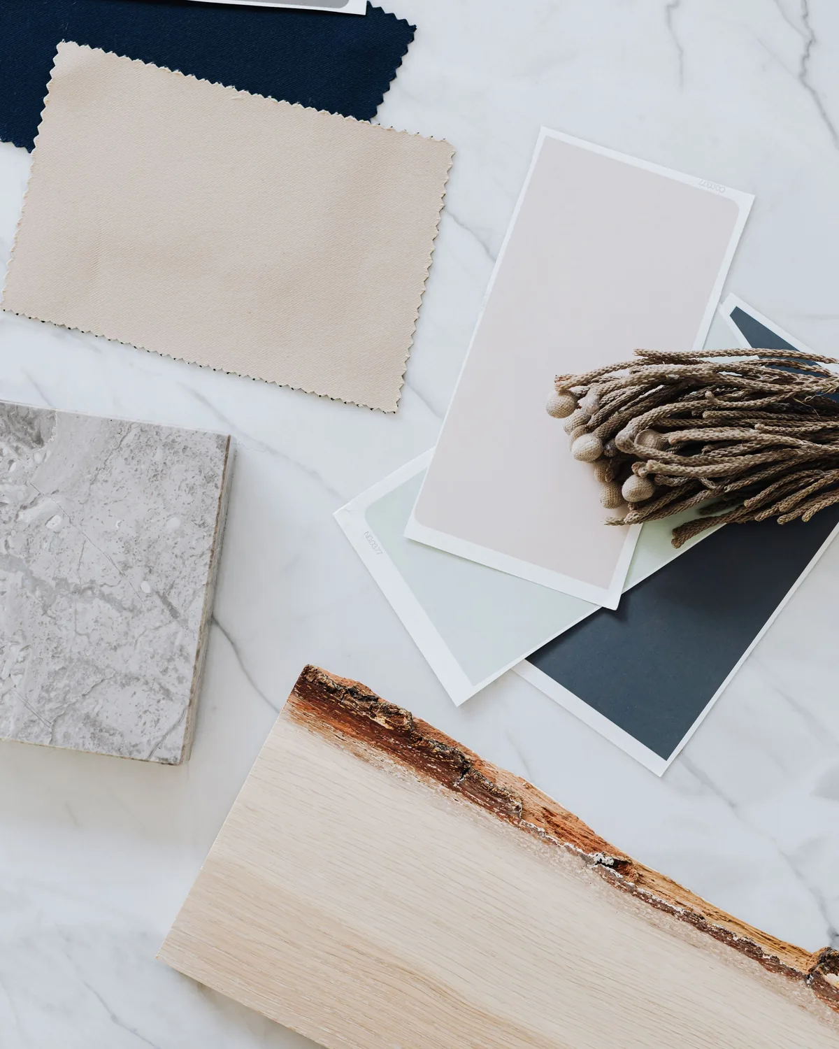 Flat lay of interior material and fabric swatches including wood, marble and textiles